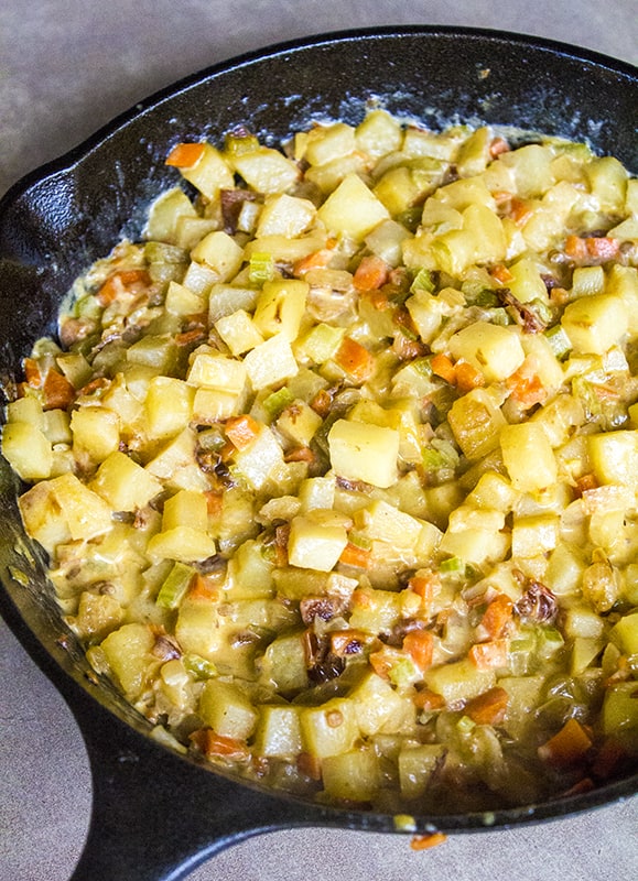 cast iron skillet with potatoes, bacon, and chipotle peppers